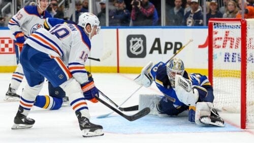 St. Louis Blues goaltender Jordan Binnington (50) gloves the puck after a shot on goal by Edmonton Oilers' Zach Hyman (18) during the first period of an NHL hockey game Thursday, Feb. 15, 2024, in St. Louis. (AP Photo/Scott Kane)