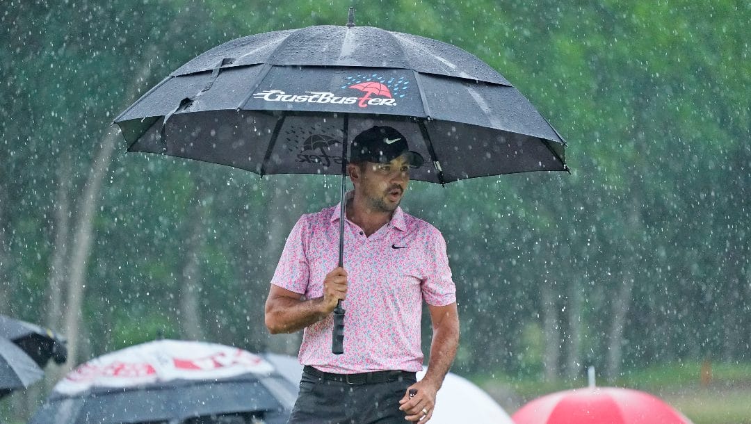 Jason Day, of Australia, stands in the rain before putting on the 18th hole during the final round of the Byron Nelson golf tournament in McKinney, Texas, Sunday, May 14, 2023.