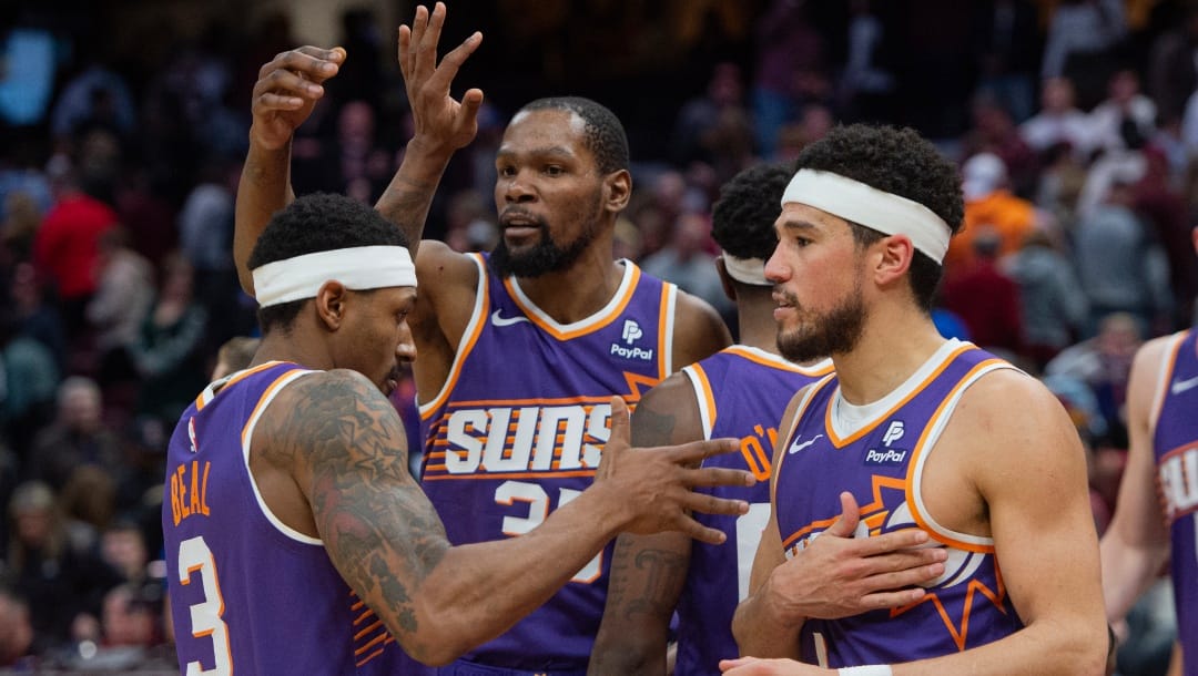Phoenix Suns' Bradley Beal (3), left, Kevin Durant, center and Devin Booker, left, celebrate after an NBA basketball game against the Cleveland Cavaliers in Cleveland, Monday, March 11, 2024.
