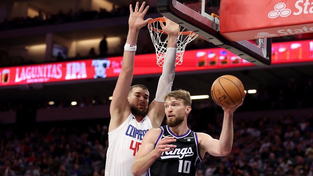 Domantas Sabonis of the Sacramento Kings is guarded by Ivica Zubac of the LA Clippers in the second half at Golden 1 Center on April 02, 2024 in Sacramento, California.