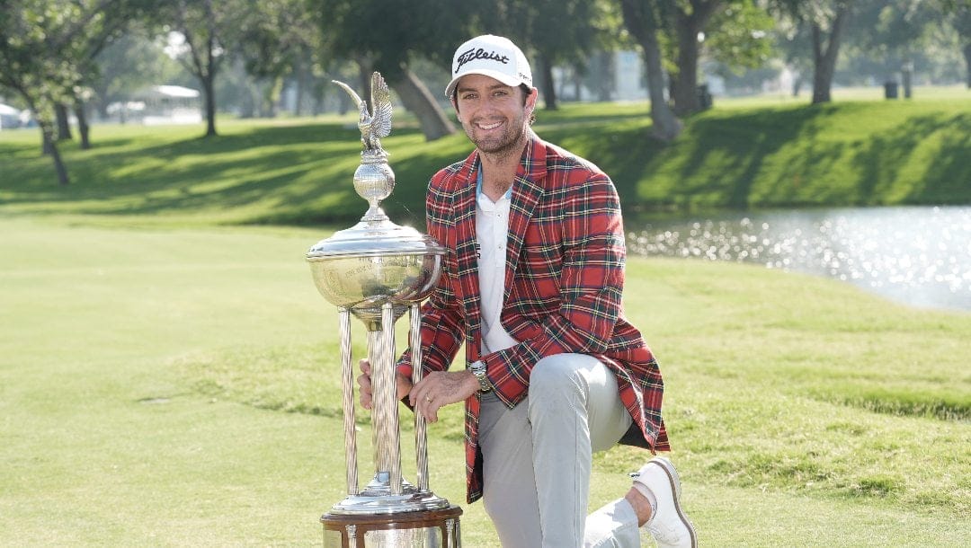 Davis Riley poses with the winner's trophy at the Charles Schwab Challenge golf tournament at Colonial Country Club in Fort Worth, Texas, Sunday, May 26, 2024.