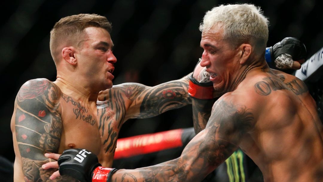 Dustin Poirier, left, fights Charles Oliveira during a lightweight mixed martial arts title bout at UFC 269, Saturday, Dec. 11, 2021.