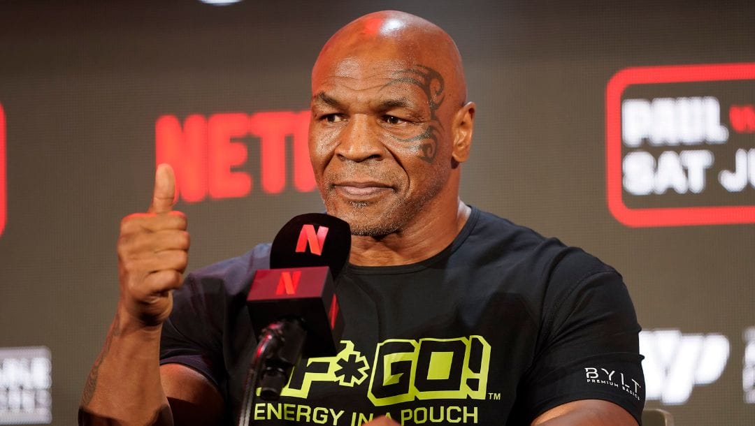 Mike Tyson gestures to the crowd during a news conference promoting his upcoming boxing bout against Jake Paul.