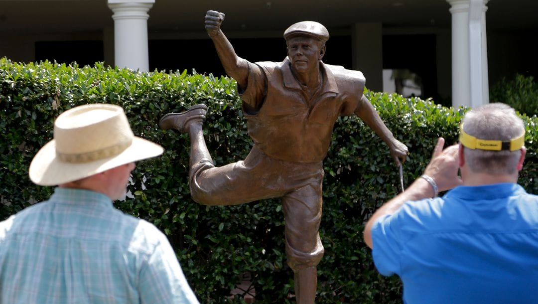 A fans takes a picture of the statue of golfer Payne Stewart that overlooks the 18th green at Pinehurst Resort & Country Club’s Course No. 2 during a practice round for the U.S. Open golf tournament in Pinehurst, N.C., Monday, June 9, 2014. The tournament starts Thursday.