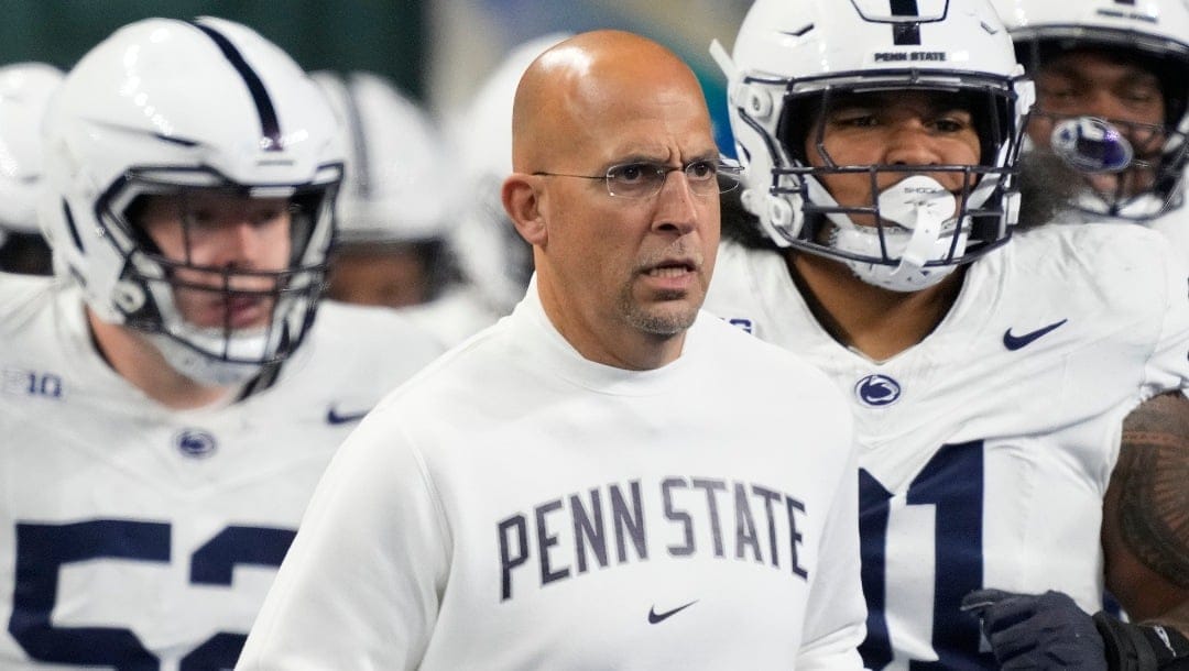 FILE - Penn State head coach James Franklin, center, runs out with his team before an NCAA college football game against Michigan State, Nov. 24, 2023, in Detroit. Mississippi will play for the first 11-win season in school history when the Rebels of the Southeastern Conference, led by quarterback Jaxson Dart, face Penn State, led by quarterback Drew Allar, in the Peach Bowl, Saturday, Dec. 30, 2023. (AP Photo/Carlos Osorio, File)