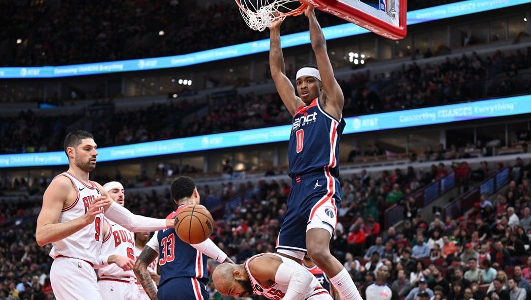 CHICAGO, ILLINOIS - MARCH 16: Bilal Coulibaly #0 of the Washington Wizards dunks over Jevon Carter #5 of the Chicago Bulls in the first half on March 16, 2024 at United Center in Chicago, Illinois.