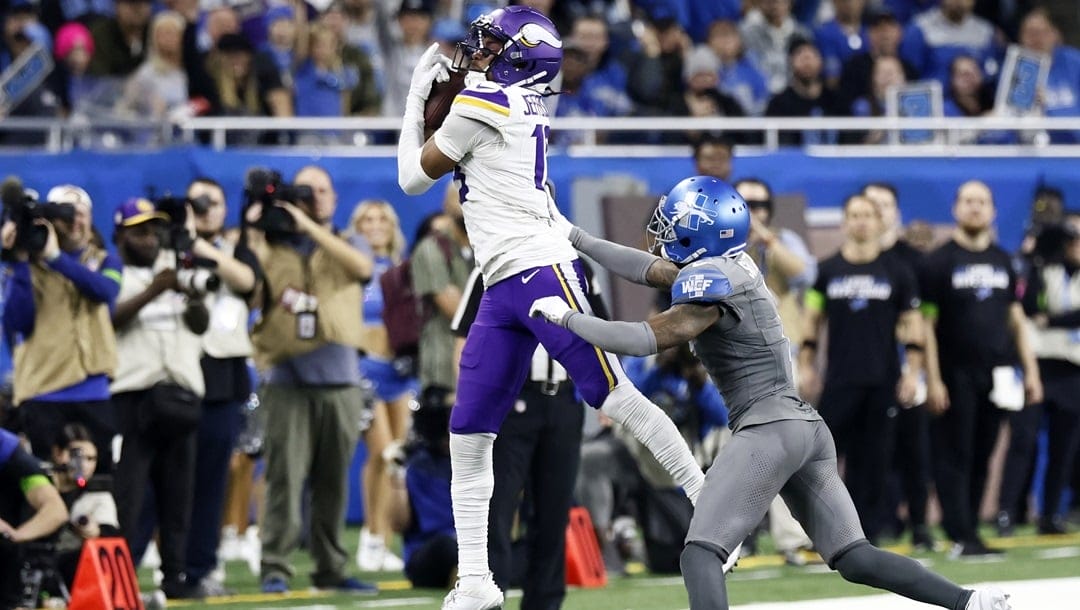 Minnesota Vikings wide receiver Justin Jefferson (18) makes a catch while being covered by Detroit Lions cornerback Cameron Sutton (1) during the second half of an NFL football game Sunday, Jan. 7, 2024, in Detroit.