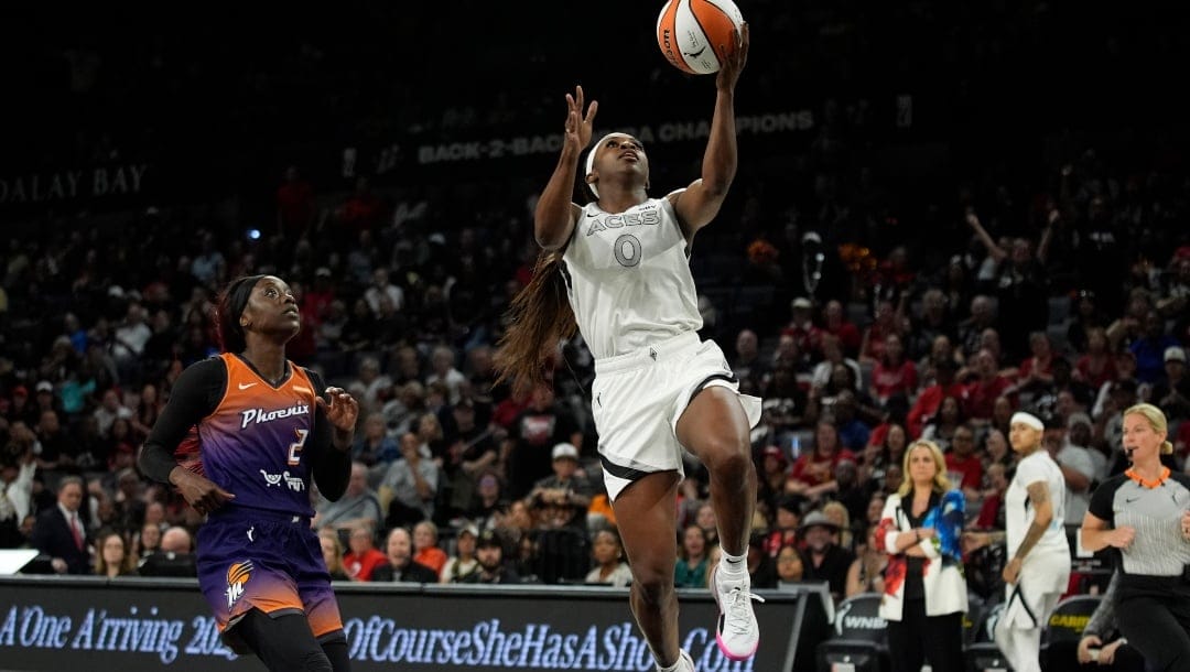 Las Vegas Aces guard Jackie Young (0) shoots over Phoenix Mercury guard Kahleah Copper (2) during the first half of a WNBA basketball game Tuesday, May 14, 2024, in Las Vegas.