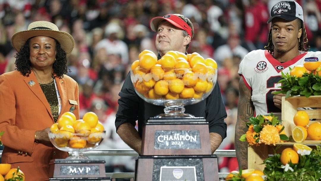 Yvonne Johnson-Phillips, left, president & chair of the Orange Bowl Committee presents trophies to Georgia head coach Kirby Smart, center, and MVP running back Kendall Milton after Georgia defeated Florida State in the Orange Bowl NCAA college football game, Saturday, Dec. 30, 2023, in Miami Gardens, Fla.
