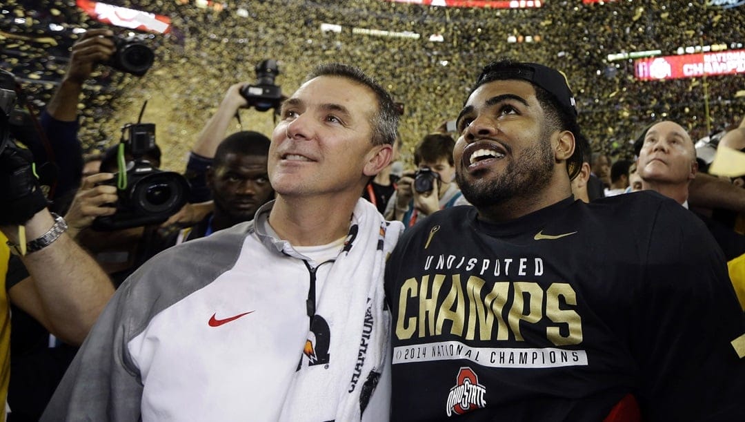 In this Jan. 12, 2015, file photo, Ohio State head coach Urban Meyer, left, and Ezekiel Elliott celebrate after they defeated Oregon 42-20 in the NCAA college football playoff championship game in Arlington, Texas. Elliott apologized for the critical comments he made about play calling after the Michigan State game and says it was the wrong time to make it known he would not be returning to school next season. Elliott posted a long apology on Twitter on Monday, Nov. 23, 2015, saying, "My intentions were not to point fingers at anyone for OUR failures."