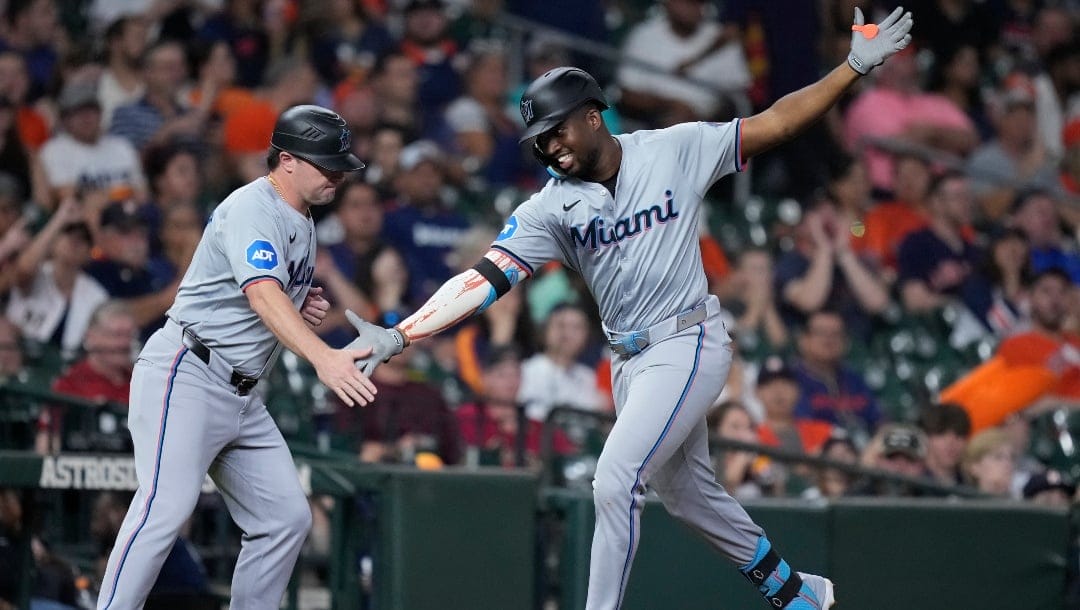 Miami Marlins' Jesús Sánchez, right, celebrates with third base coach Griffin Benedict, left, after hitting a solo home run during the seventh inning of a baseball game against the Houston Astros Tuesday, July 9, 2024, in Houston.