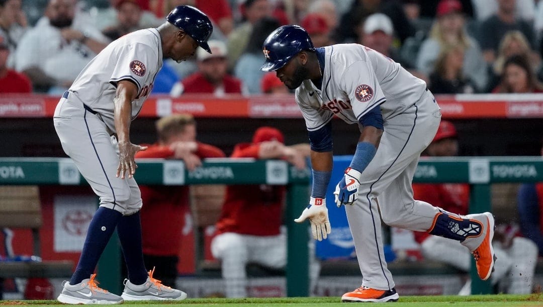 Houston Astros' Yordan Alvarez, right, celebrates his two-run home run with third base coach Gary Pettis during the fifth inning of the team's baseball game against the Los Angeles Angels, Saturday, June 8, 2024, in Anaheim, Calif.