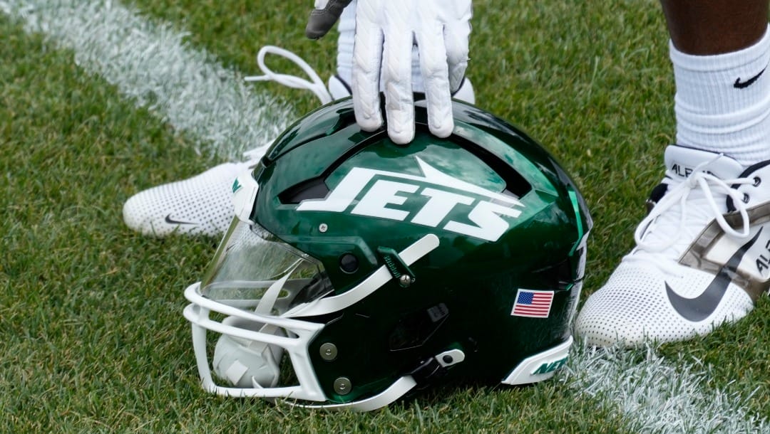 A New York Jets player picks up a helmet during practice at the NFL football team's training facility in Florham Park, N.J., Tuesday, June 11, 2024. (AP Photo/Pamela Smith)