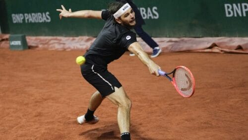 Taylor Fritz, of the United States, plays a shot against Greece's Thanasi Kokkinakis during their third-round match of the French Open tennis tournament at the Roland Garros stadium in Paris, June 1, 2024. For the first time in more than 30 years, the tennis competition at an Olympics will be held on red clay, which means players who just made the adjustment from that surface at the French Open in early June to grass at Wimbledon in early July now will need to reverse course again in short order.