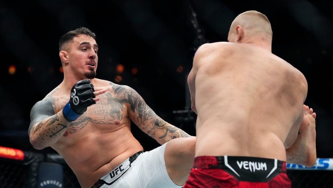 England's Tom Aspinall, left, kicks Russia's Sergei Pavlovich during the first round of a heavyweight title bout at the UFC 295.