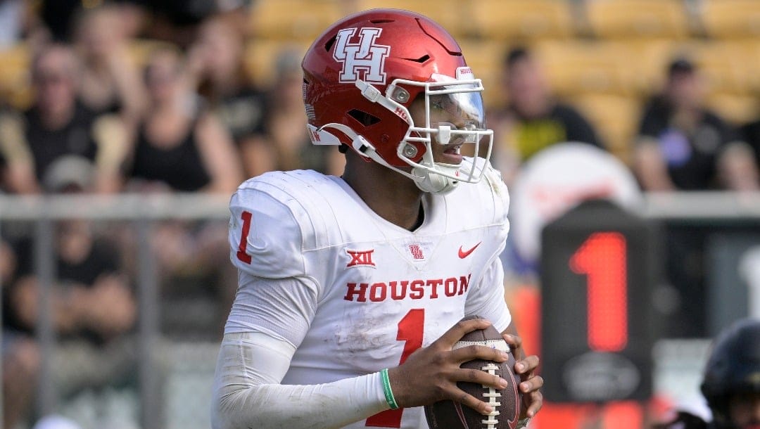 Houston quarterback Donovan Smith (1) looks for a receiver as Central Florida defensive end Tre'Mon Morris-Brash (3) gives chase during the second half of an NCAA college football game, Saturday, Nov. 25, 2023, in Orlando, Fla. (AP Photo/Phelan M. Ebenhack)