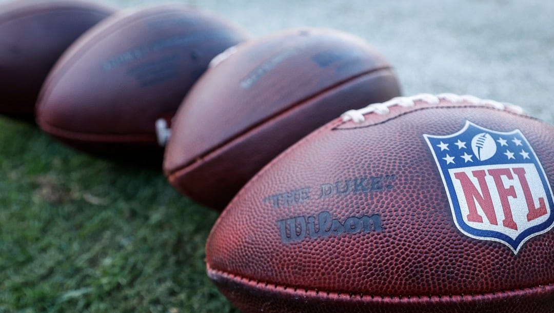 Wilson footballs sit on the field before an NFL football game between the Chicago Bears and Las Vegas Raiders, Sunday, Oct. 22, 2023, in Chicago. (AP Photo/Kamil Krzaczynski)