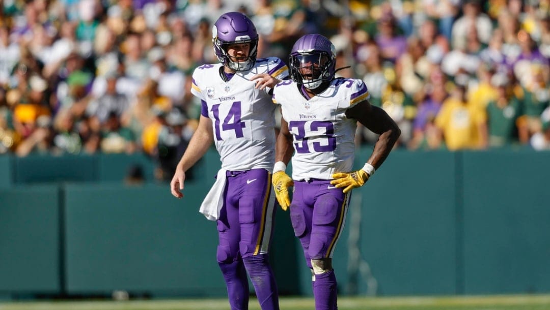 Minnesota Vikings quarterback Sam Darnold (14) and Minnesota Vikings running back Aaron Jones (33) on the field during a NFL game against the Green Bay Packers Sunday, Sept. 29, 2024, in Green Bay, Wis.