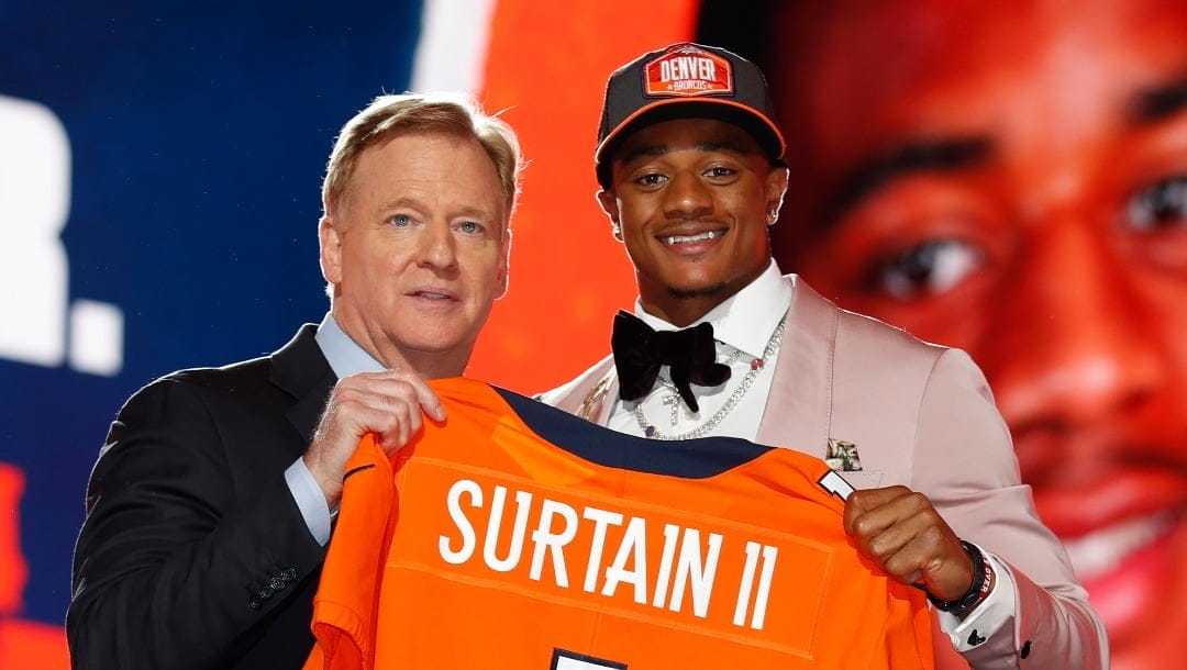 Alabama cornerback Patrick Surtain II, right, holds a team jersey with NFL Commissioner Roger Goodell after he was chosen by the Denver Broncos with the ninth pick in the NFL football draft, Thursday, April 29, 2021, in Cleveland.