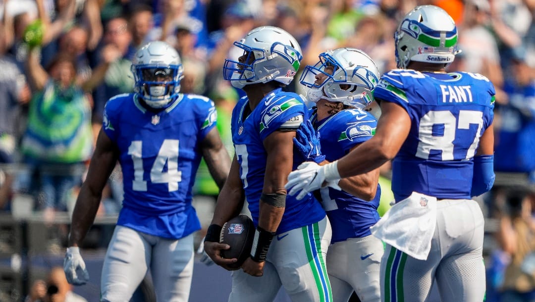 Seattle Seahawks quarterback Geno Smith (7) celebrates scoring a touchdown with wide receiver DK Metcalf (14), wide receiver Jaxon Smith-Njigba, third from left, and tight end Noah Fant (87) during an NFL football game against the Denver Broncos, Sunday, Sept. 8, 2024, in Seattle. The Seahawks won 26-20. (AP Photo/Lindsey Wasson)