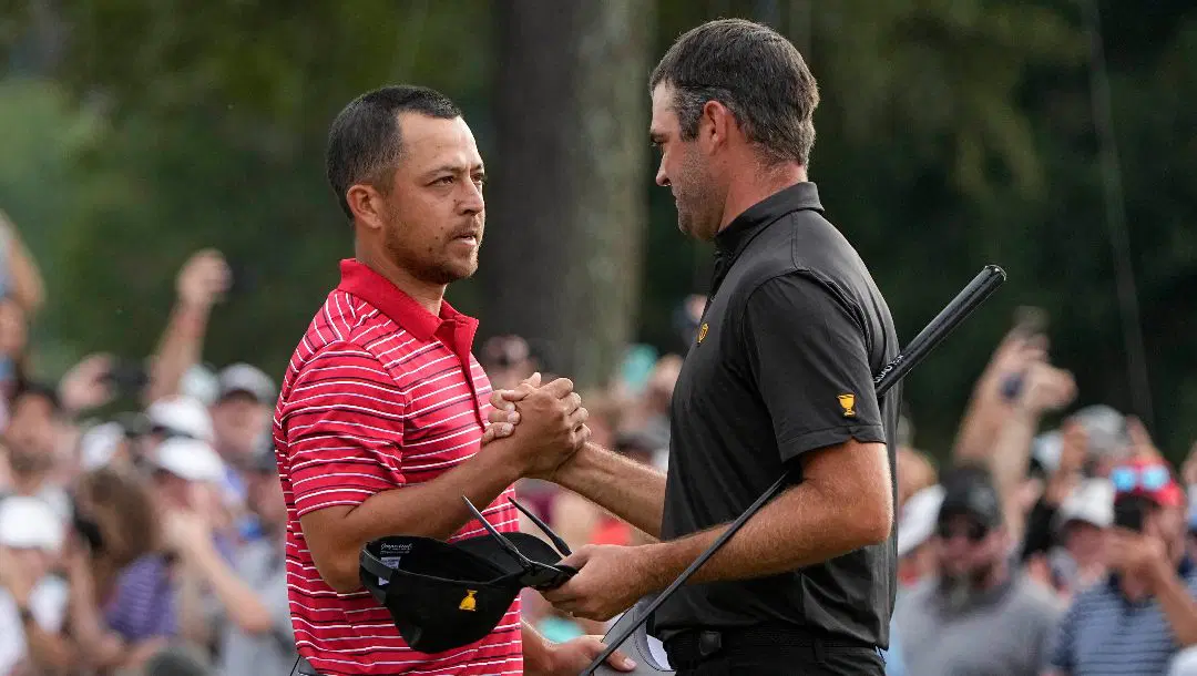 Xander Schauffele speaks with Corey Conners, of Canada, after Schauffele won the hole on the 18th green during their singles match at the Presidents Cup golf tournament at the Quail Hollow Club, Sunday, Sept. 25, 2022, in Charlotte, N.C. Team USA won the Presidents Cup golf tournament.