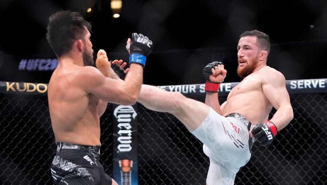 Merab Dvalishvili, right, throws a kick at Henry Cejudo during their bantamweight bout at the UFC 298 mixed martial arts event.