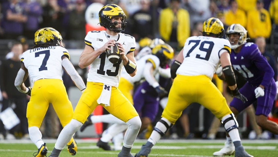 Michigan quarterback Jack Tuttle (13) looks to pass against Washington during the first half of an NCAA college football game Saturday, Oct. 5, 2024, in Seattle.