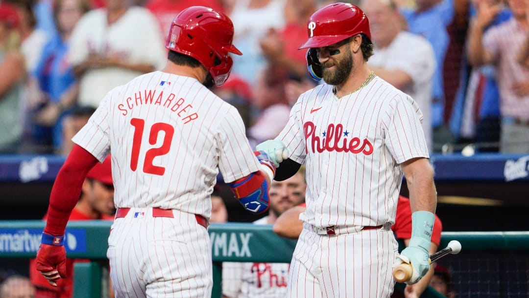 Philadelphia Phillies' Kyle Schwarber (12) celebrates his solo home run with Bryce Harper during the first inning of a baseball game against the Tampa Bay Rays, Tuesday, Sept. 10, 2024, in Philadelphia.