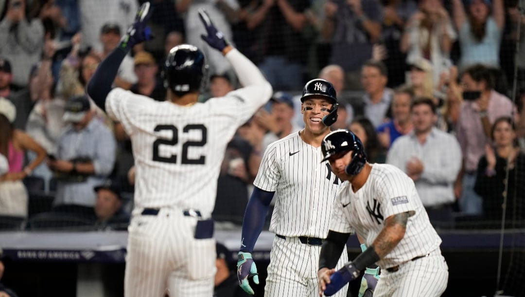 New York Yankees' Aaron Judge, center, and Gleyber Torres, right, watch as Juan Soto (22) celebrates after hitting a two-run home run during the sixth inning of a baseball game against the Kansas City Royals at Yankee Stadium Wednesday, Sept. 11, 2024, in New York.