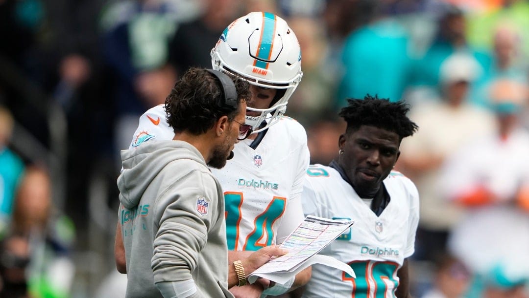 Miami Dolphins head coach Mike McDaniel talks with quarterback Tim Boyle (14) as he comes into the game as wide receiver Tyreek Hill (10) looks on during an NFL football game against the Seattle Seahawks, Sunday, Sept. 22, 2024 in Seattle. The Seahawks won 24-3. (AP Photo/Lindsey Wasson)