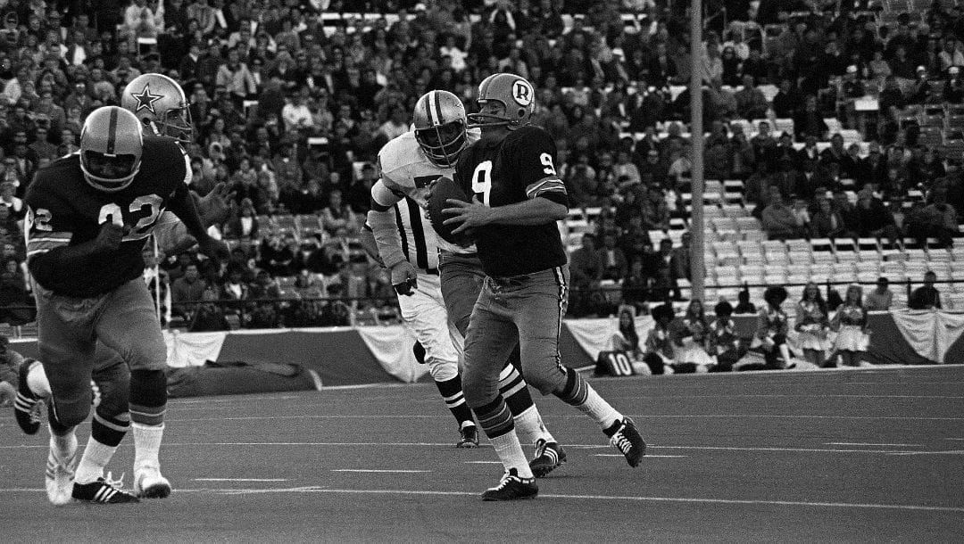 Washington Redskins quarterback Sonny Jorgensen (9) is about be overwhelmed by Dallas Cowboys George Andrie (66) and Jethro Pugh (75) as he scrambles in first quarter action, Dec. 6, 1970 in Dallas. Jorgensen was dropped for a 4-yard loss on the play, as he was unable to find a receiver open.