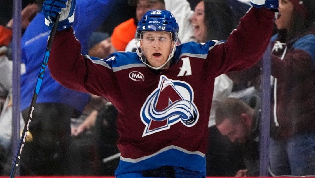 Colorado Avalanche center Nathan MacKinnon (29) celebrates after scoring the winning goal in overtime of an NHL hockey game Friday, Oct. 18, 2024, in Denver. (AP Photo/David Zalubowski)