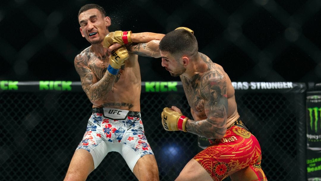 Champion Ilia Topuria, right, battles Max Holloway during a mixed martial arts featherweight title bout at UFC Fight Night.