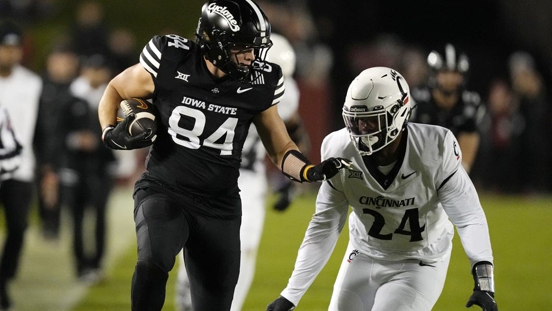 Iowa State tight end Gabe Burkle (84) runs from Cincinnati defensive end Darian Varner (24) after catching a pass during the first half of an NCAA college football game, Saturday, Nov. 16, 2024, in Ames, Iowa.