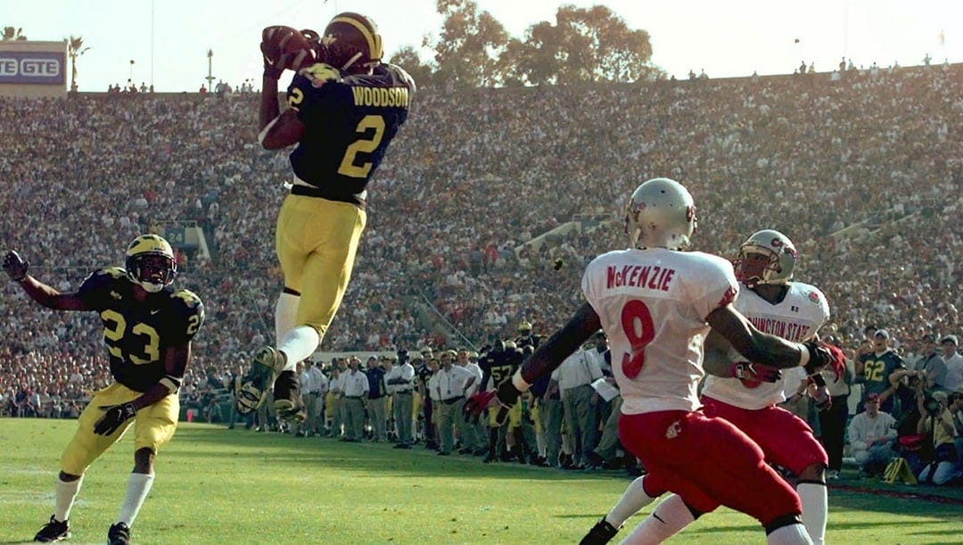 Michigan's cornerback Charles Woodson (2) leaps to make an interception in the end zone in the first half on a pass from Washington State's Ryan Leaf during the 84th Rose Bowl in Pasadena, Calif., Thursday, Jan. 1, 1998. Watching the play are Michigan's William Peterson (23) and Washington States Kevin McKenzie (9). Player at right unidentified.