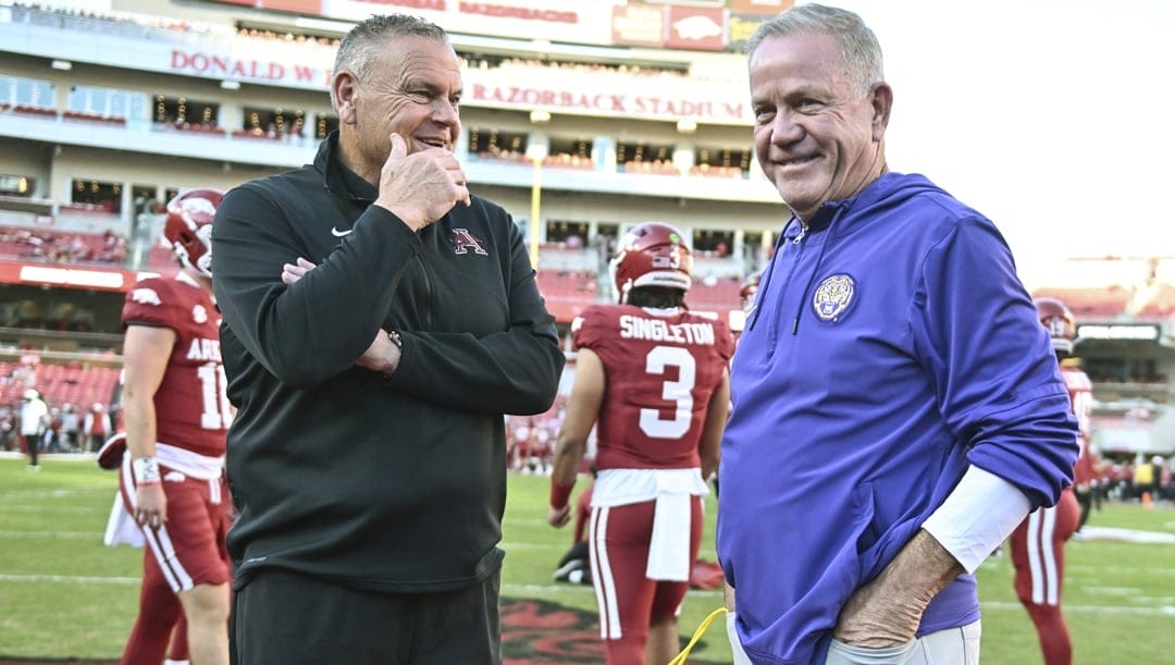 Arkansas coach Sam Pittman, left, and LSU coach Brian Kelly talk before an NCAA college football game Saturday, Oct. 19, 2024, in Fayetteville, Ark.