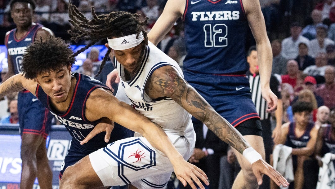 Dayton guard Javon Bennett (0) and Richmond guard DeLonnie Hunt (3) go after a loose ball during the first half of an NCAA college basketball game on Saturday, Jan. 27, 2024 in Richmond, Va. (AP Photo/Shaban Athuman)