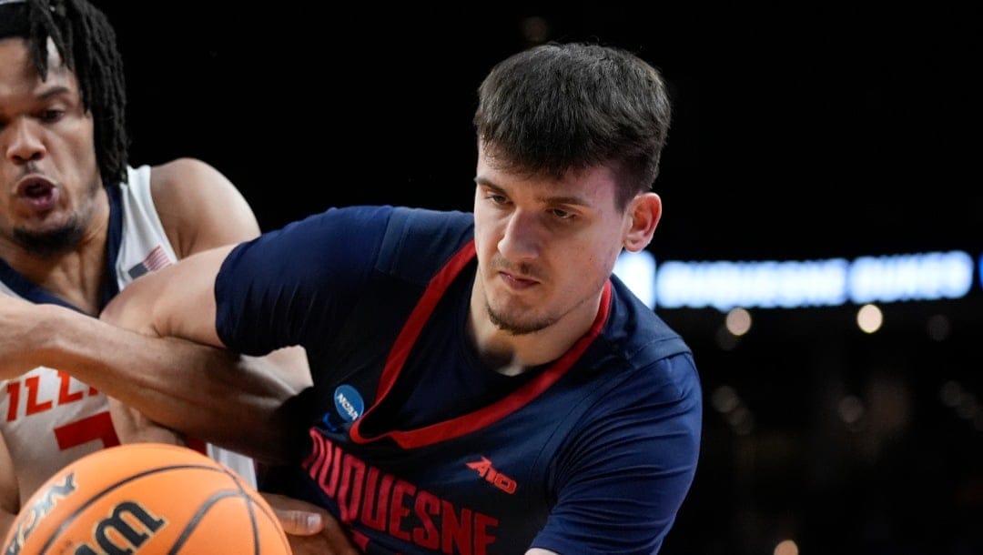 Duquesne guard Jake DiMichele, right, and Illinois forward Ty Rodgers (20) fight for a rebound in the second half of a second-round college basketball game in the NCAA Tournament, Saturday, March 23, 2024, in Omaha, Neb. (AP Photo/Charlie Neibergall)