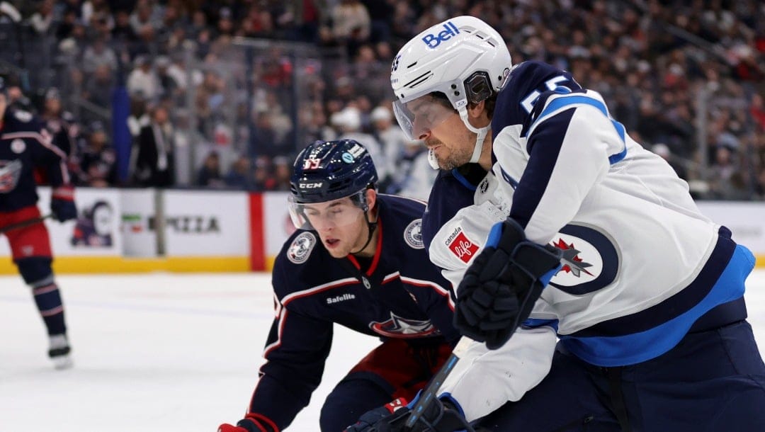 Winnipeg Jets forward Mark Scheifele, right, controls the puck in front of Columbus Blue Jackets forward Yegor Chinakhov during an NHL hockey game in Columbus, Ohio, Friday, Nov. 1, 2024. The Jets won 6-2. (AP Photo/Paul Vernon)