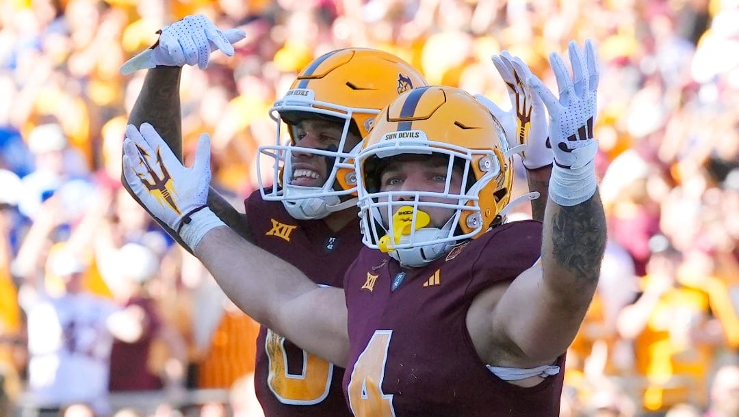 Arizona State running back Cam Skattebo (4) celebrates a touchdown against BYU with wide receiver Jordyn Tyson (0) and offensive lineman Kyle Scott (77) during the first half of an NCAA college football game Saturday, Nov. 23, 2024, in Tempe, Ariz. Arizona State won 28-23. (AP Photo/Ross D. Franklin)