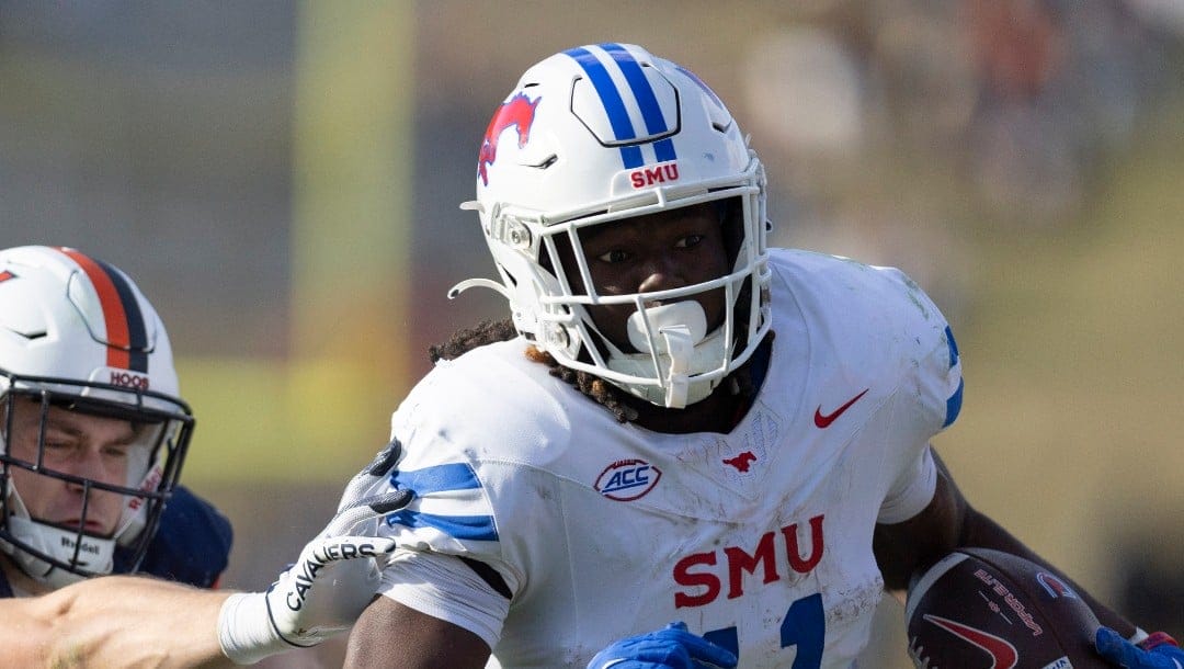 SMU running back LJ Johnson Jr. (11) defends the ball from Virginia safety Ethan Minter (30)during the second half of an NCAA college football game, Saturday, Nov. 23, 2024, in Charlottesville, Va. (AP Photo/Mike Kropf)