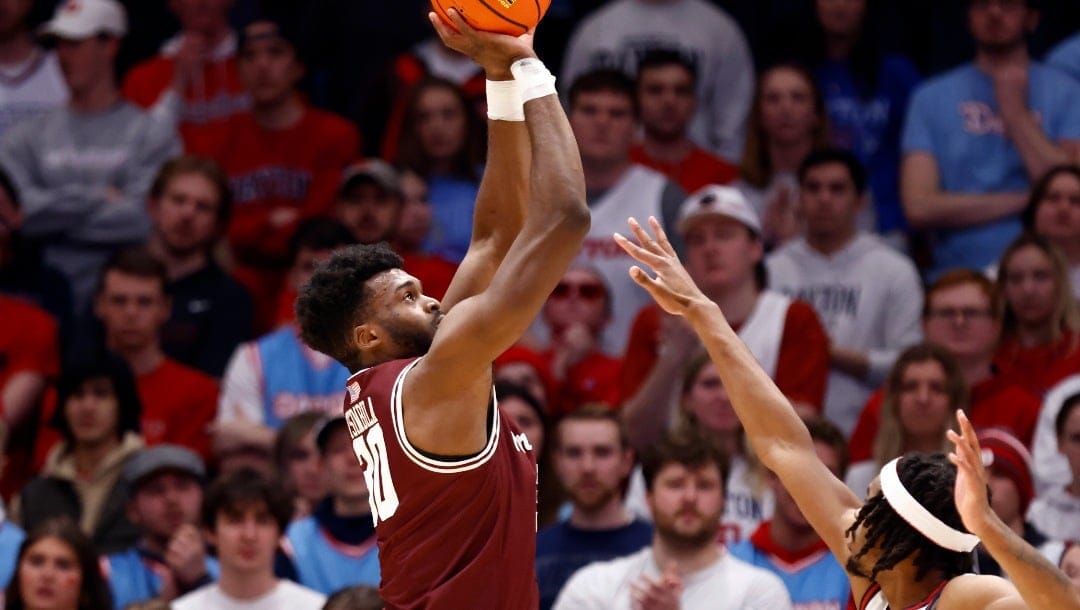 Fordham forward Abdou Tsimbila, left, shoots in front of Dayton forward DaRon Holmes during an NCAA college basketball game in Dayton, Ohio, Saturday, Feb. 17, 2024. (AP Photo/Paul Vernon)