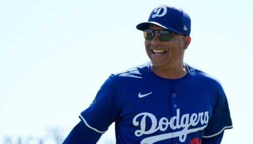 Los Angeles Dodgers manager Dave Roberts smiles at fans as he heads to the dugout prior to a spring training baseball game against the Cleveland Guardians, Tuesday, March 11, 2025, in Phoenix. (AP Photo/Ross D. Franklin)