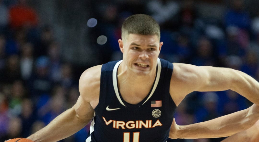 Virginia guard Isaac McKneely (11) drives on Florida forward Alex Condon, right, during the first half of an NCAA college basketball game Wednesday, Dec. 4, 2024, in Gainesville, Fla. (AP Photo/Alan Youngblood)