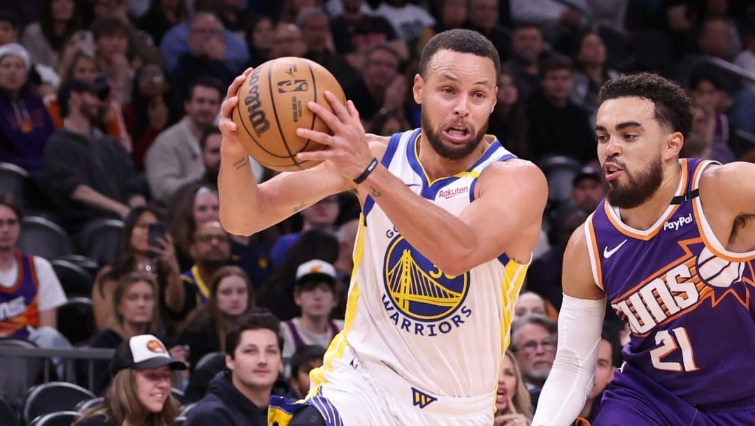 PHOENIX, ARIZONA - NOVEMBER 30: Stephen Curry #30 of the Golden State Warriors drives to the basket against Tyus Jones #21 of the Phoenix Suns during the second half at Footprint Center on November 30, 2024 in Phoenix, Arizona. NOTE TO USER: User expressly acknowledges and agrees that, by downloading and or using this photograph, User is consenting to the terms and conditions of the Getty Images License Agreement.