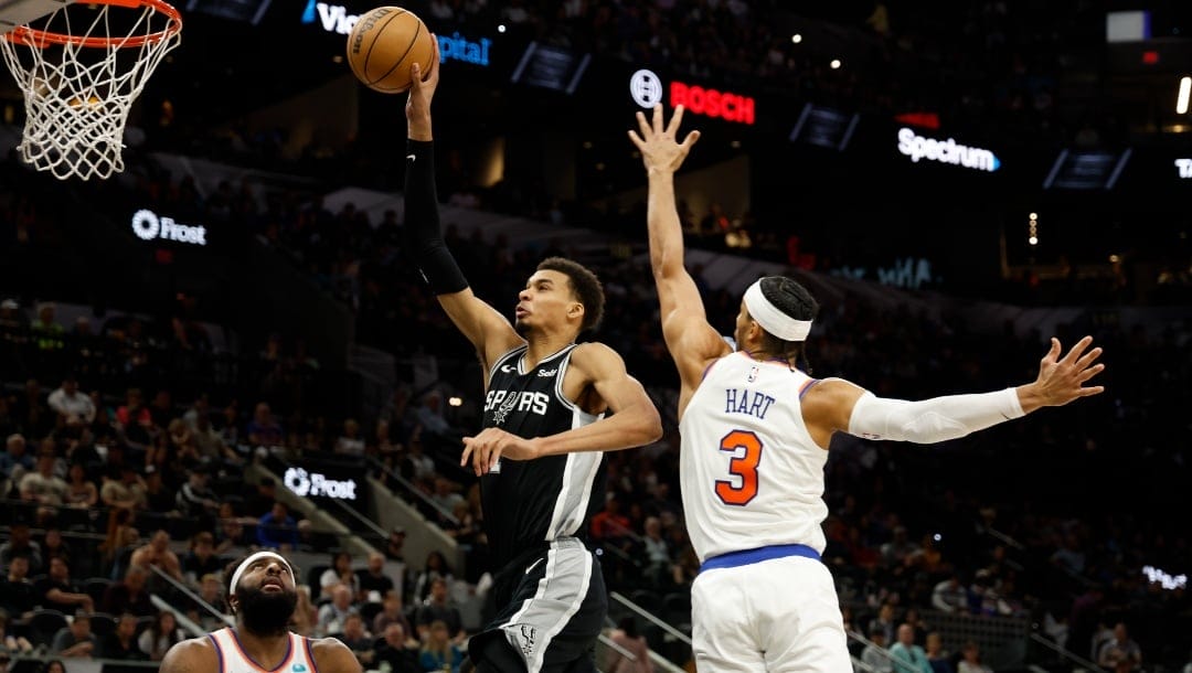 Victor Wembanyama #1 of the San Antonio Spurs drives past Josh Hart #3 of the New York Knicks in the first half at Frost Bank Center on March 29, 2024 in San Antonio, Texas.