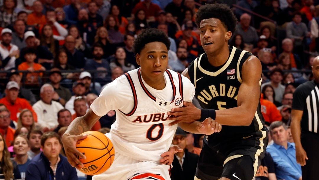 Auburn guard Tahaad Pettiford (0) drives the baseline around Purdue guard Myles Colvin (5) during the first half of an NCAA college basketball game, Saturday, Dec. 21, 2024, in Birmingham, Ala.