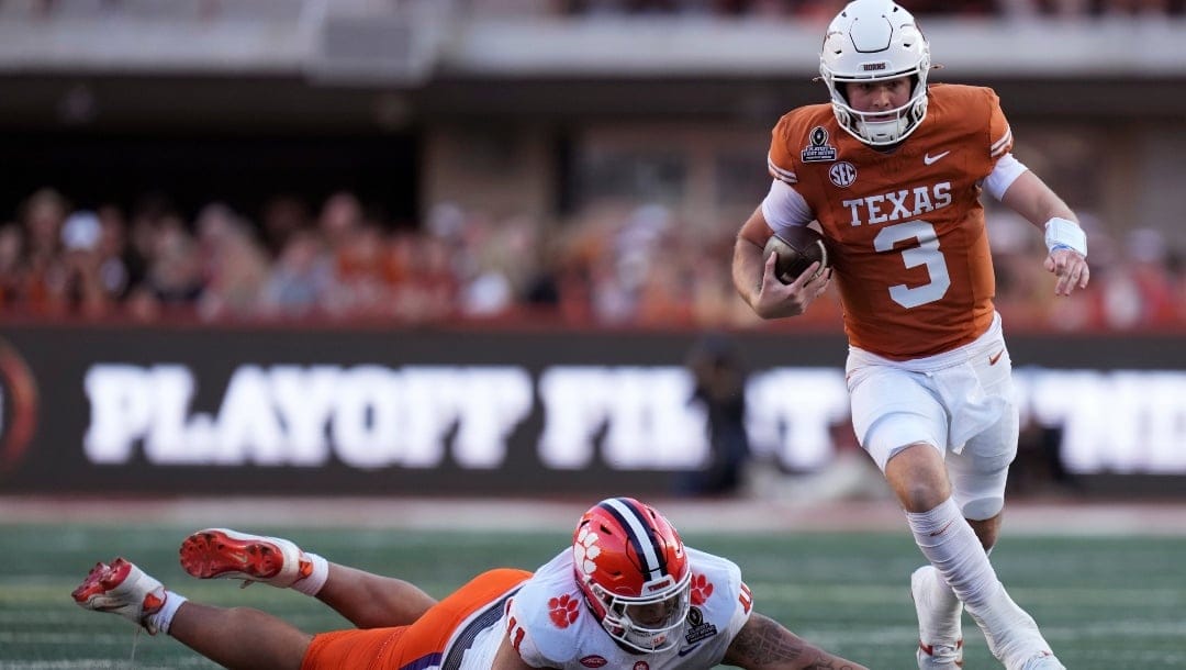 Texas quarterback Quinn Ewers (3) runs from Clemson defensive lineman Peter Woods during the first half in the first round of the College Football Playoff, Saturday, Dec. 21, 2024, in Austin, Texas.