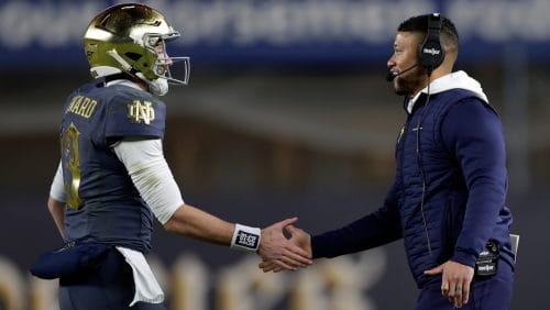 Notre Dame quarterback Riley Leonard (13) slaps hands with head coach Marcus Freeman during the first half of an NCAA college football game against Army at Yankee Stadium on Saturday, Nov. 23, 2024, in New York.