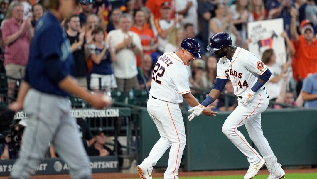 Houston Astros' Yordan Alvarez (44) celebrates with third base coach Omar Lopez (22) after hitting a three-run home run off Seattle Mariners starting pitcher Logan Gilbert, left, during the third inning of a baseball game Saturday, Aug. 21, 2021, in Houston.